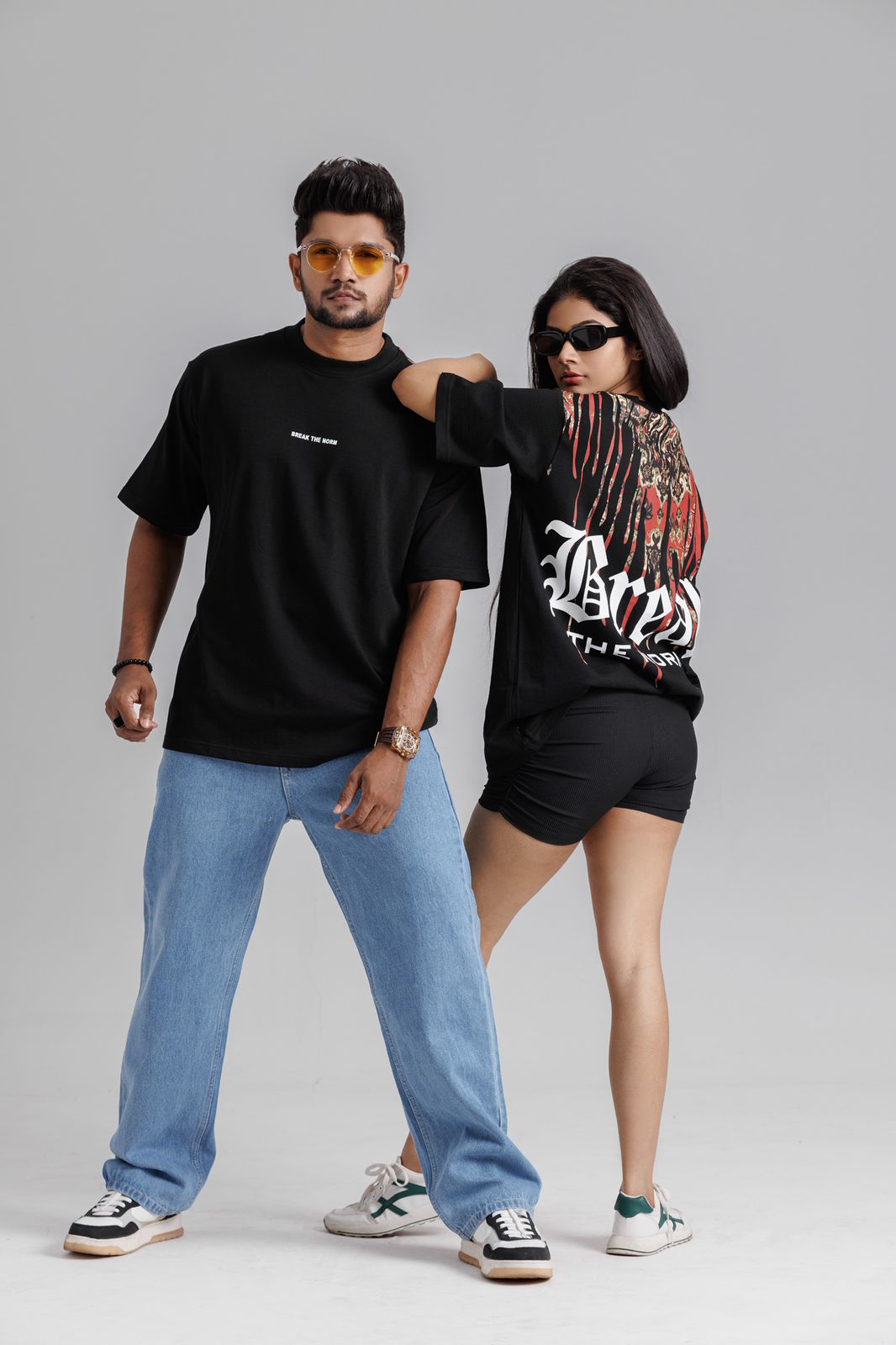 Two people standing close together on a gray background