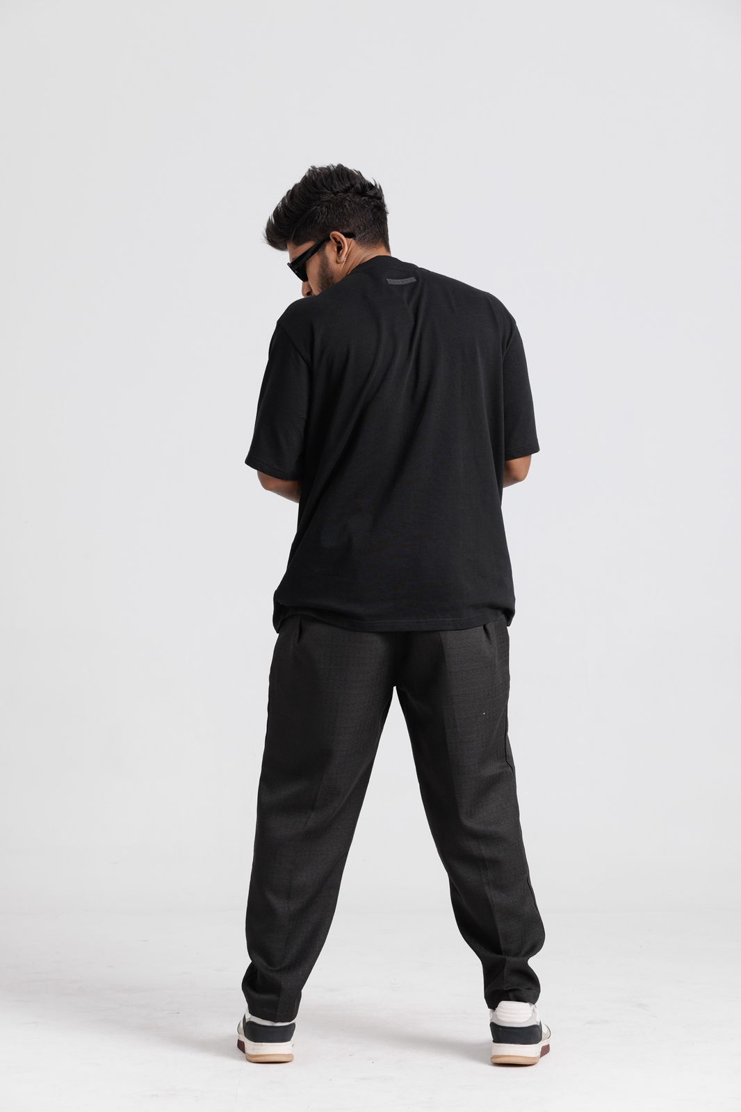 Person wearing a black t-shirt and pants on a white background