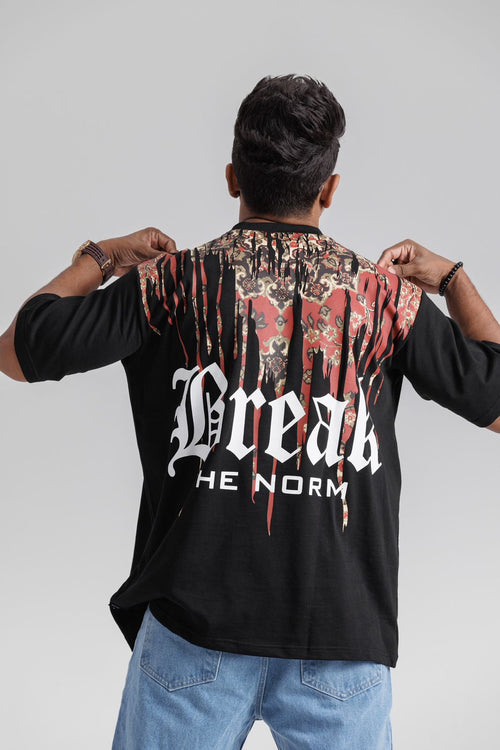 Person wearing a black shirt with 'Break the Norm' text and colorful back design.