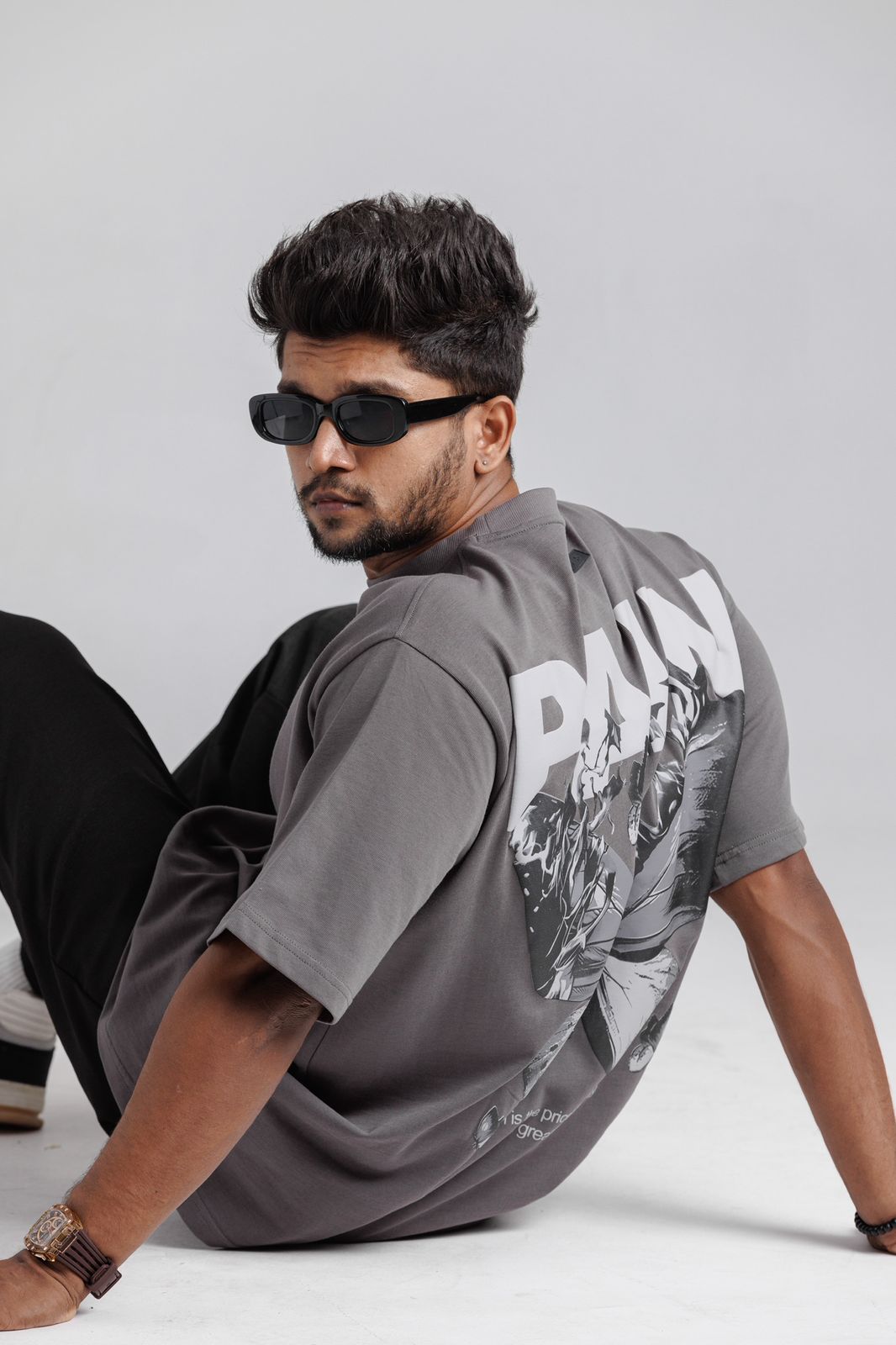 Man wearing a gray t-shirt with 'Palm' branding, sitting on a light gray background